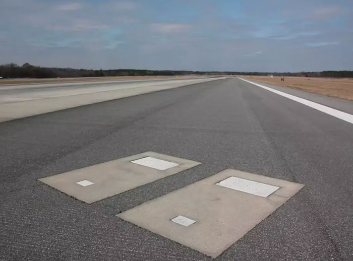 Airport runway with two grave markers in the pavement, highlighting the unique story of the graves Airport runway with two grave markers in the pavement, highlighting the unique story of the graves