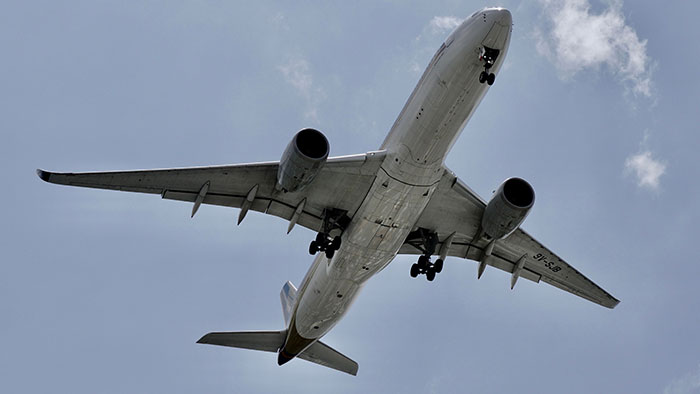 Airplane taking off from an airport, showcasing the airport's unusual grave placement Airplane taking off from an airport, showcasing the airport's unusual grave placement