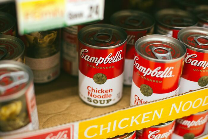 Rows of Campbell's Chicken Noodle Soup cans on a shelf, an ordinary item in a life story.