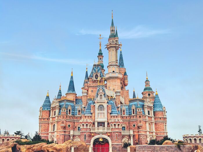A majestic castle with blue and red accents under a bright sky, representing surprising things wealthy people buy.