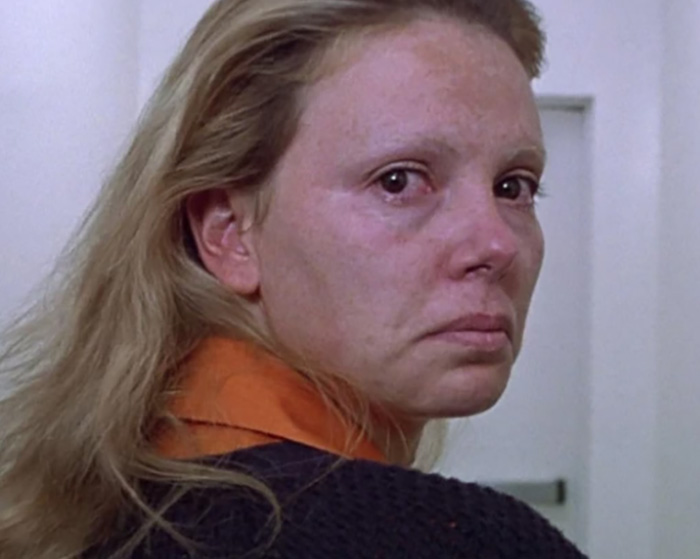 Close-up of Charlize Theron as a disturbing criminal in a prison uniform with an emotional expression Close-up of Charlize Theron as a disturbing criminal in a prison uniform with an emotional expression