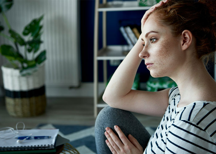 Woman looking worried, contemplating child-free celebration and in-laws demanding special exceptions.