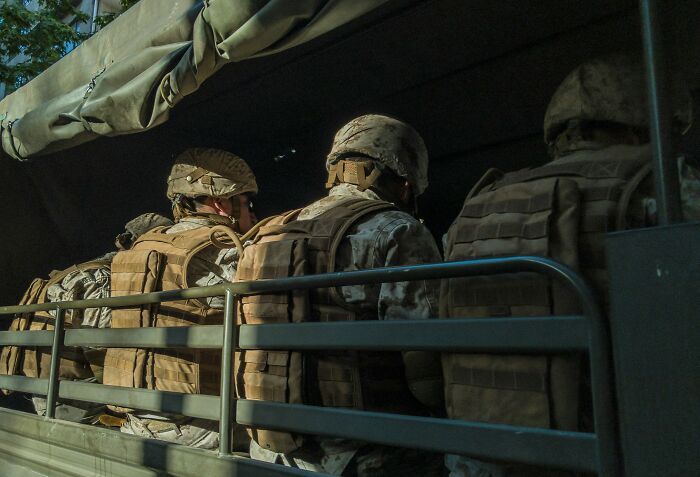 Soldiers in military gear riding in a truck, representing the peaceful future of 2027.