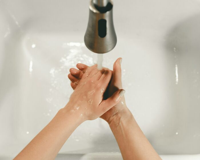 Person washing hands in a sink, an ordinary thing people do that others might judge.