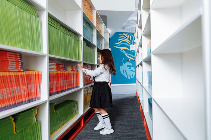 A young female student in uniform reaching for a book on a tall bookshelf in a library. This student finds a perfect way to drive her teacher crazy. A young female student in uniform reaching for a book on a tall bookshelf in a library. This student finds a perfect way to drive her teacher crazy.