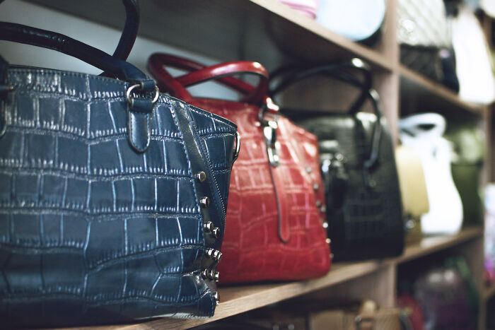 A collection of luxury handbags on display, illustrating surprising things wealthy people buy.