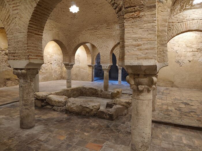 Ancient Roman bath ruins with arched brickwork and stone pillars, showcasing historical facts.