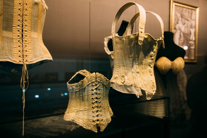 Several vintage corsets on display, representing fashion from different historical periods.
