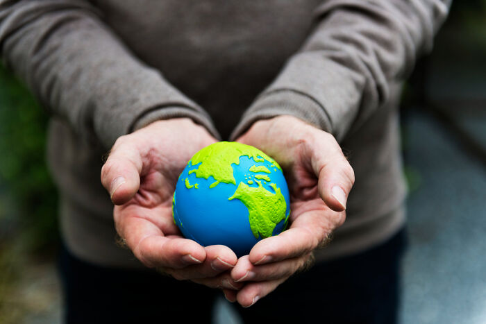 Historical facts about Earth: Cupped hands holding a small globe, representing beliefs people have.