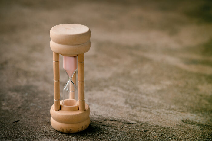 An hourglass on a textured surface, symbolizing the passage of time and historical facts.