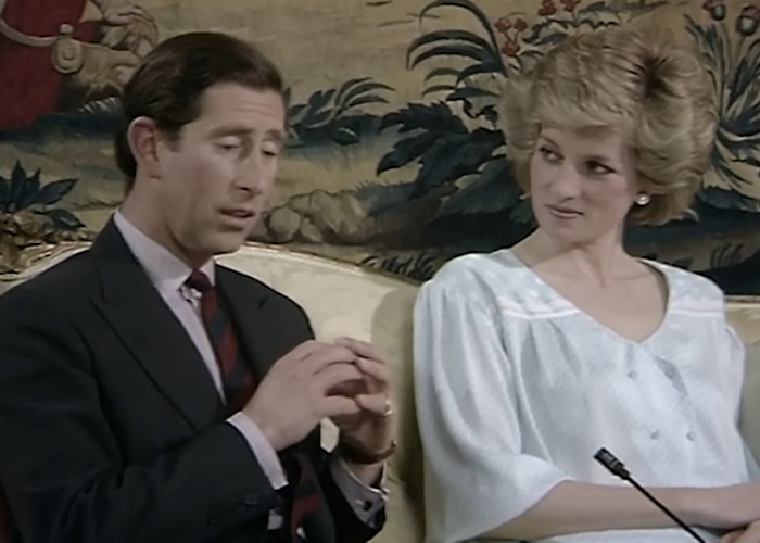 Prince Charles speaking while Princess Diana listens, showing royal public behavior and interaction.