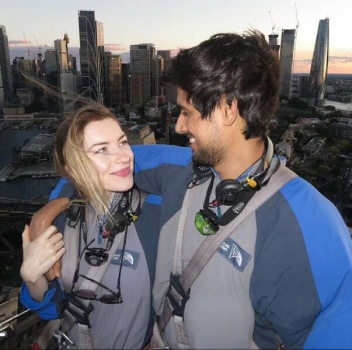 A man and woman pose together, but an optical illusion makes you look twice at where his arm is placed.
