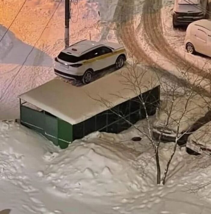 A white car parked on a snow-covered roof that makes you look once, twice