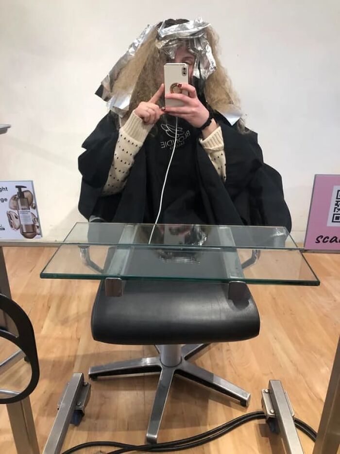 A girl taking a selfie at a salon that might make you look twice