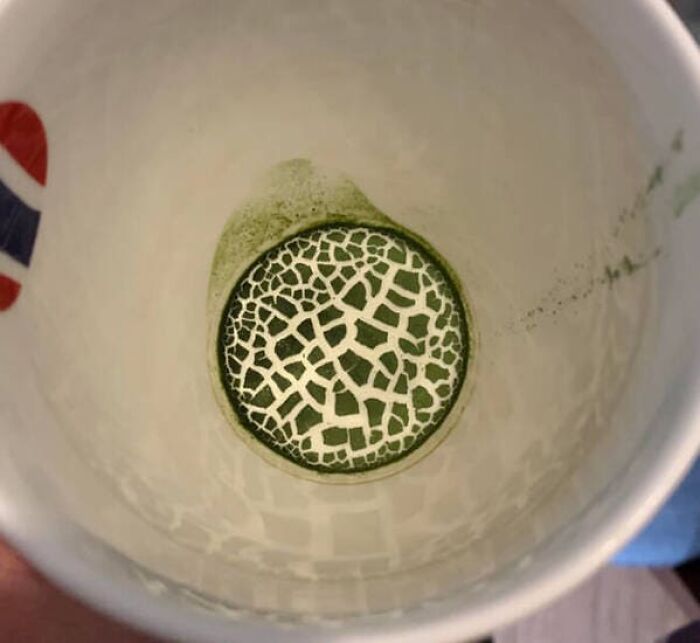 Dry green matcha powder at the bottom of a white mug forming a pattern that will make you look twice.