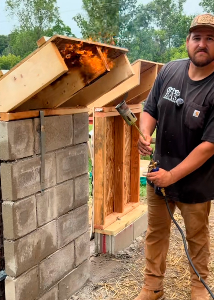 Construction expert using a torch on a wood frame to illustrate home building methods in USA vs Europe. Construction expert using a torch on a wood frame to illustrate home building methods in USA vs Europe.