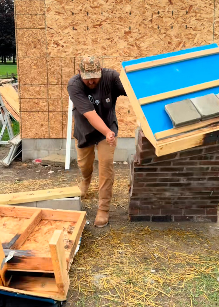 A man demonstrating the strength of USA vs Europe home building by trying to knock down a brick structure. A man demonstrating the strength of USA vs Europe home building by trying to knock down a brick structure.
