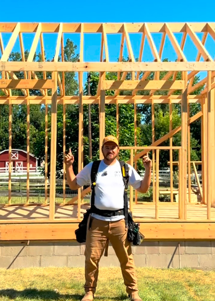Construction expert standing in the wooden frame of a home, discussing the USA vs Europe home building debate. Construction expert standing in the wooden frame of a home, discussing the USA vs Europe home building debate.