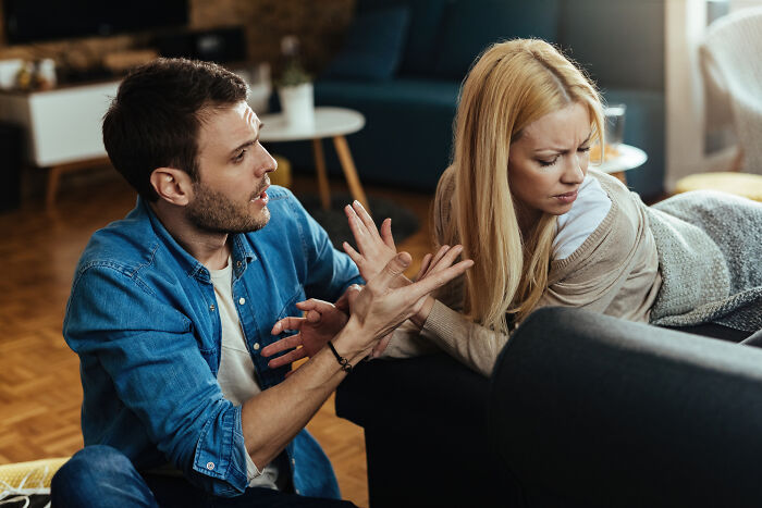 Frustrated man trying to talk to an annoyed woman on a sofa, representing how marriages couldn’t be saved