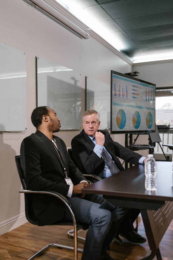 Male coworkers in a business meeting looking at a chart screen