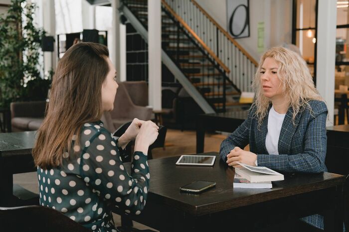 Two female coworkers discussing inappropriate remarks they have heard from male colleagues.
