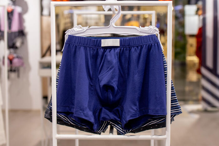 Blue men's boxer briefs hanging on a clothing rack, representing unsettling secrets hidden in a relationship.