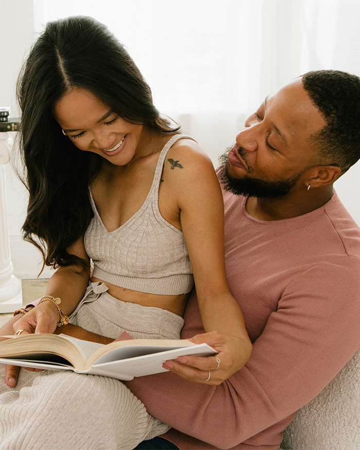 A happy couple, a woman and a man, reading a book together. This image reflects a disturbing new shaming trend.