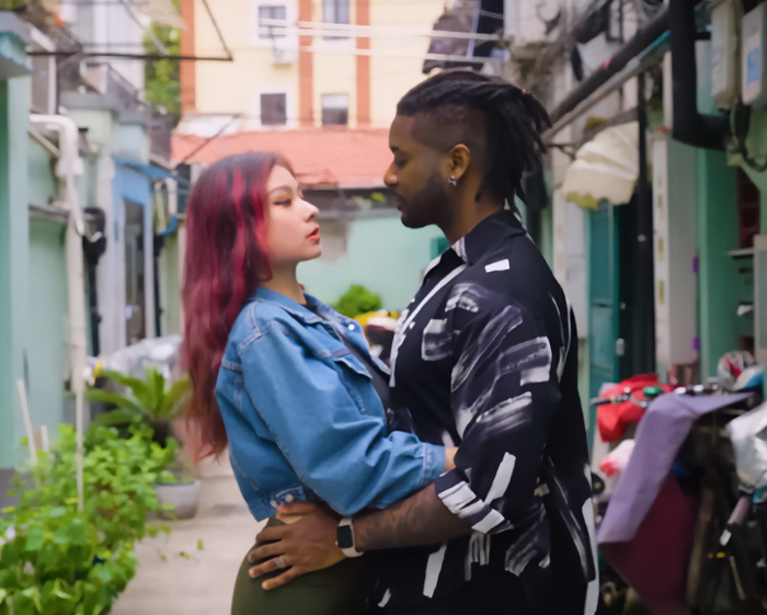 A woman dating a foreigner, embracing in an alleyway, illustrating the shaming trend.