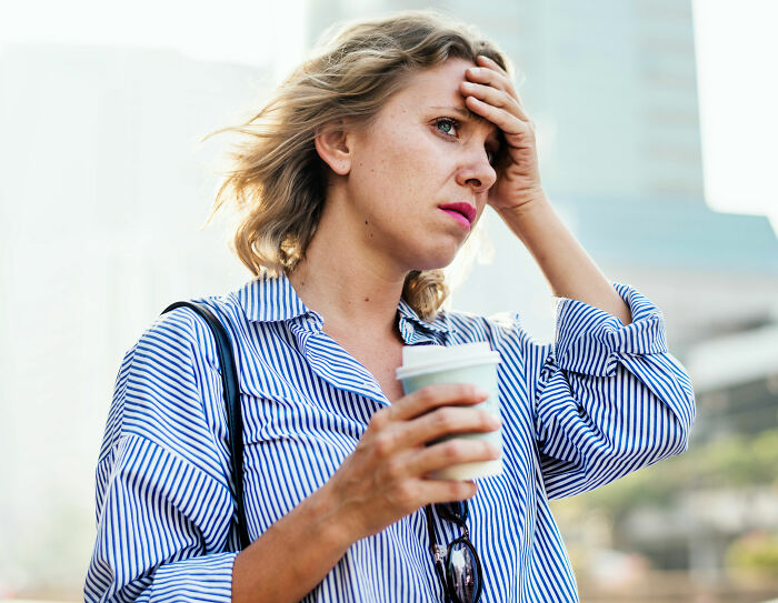 A woman looking distressed and holding her head, reflecting on the unhinged lies men share.