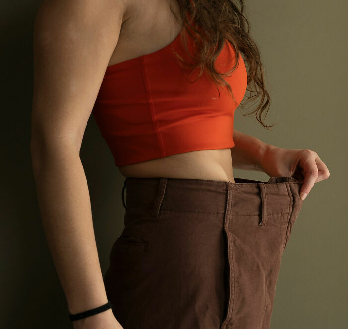 A person with loose-fitting pants, illustrating significant weight loss, a health symptom that can terrify doctors.