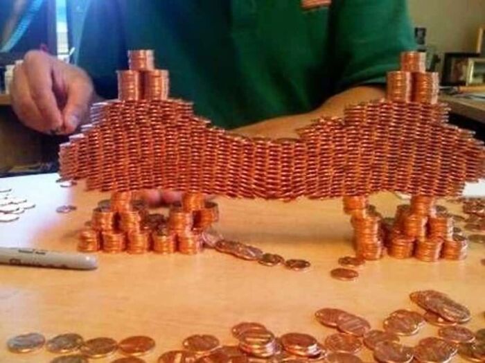An intricate structure made entirely of stacked pennies, a baffling image that seems to make absolutely no physical sense with its delicate balance.