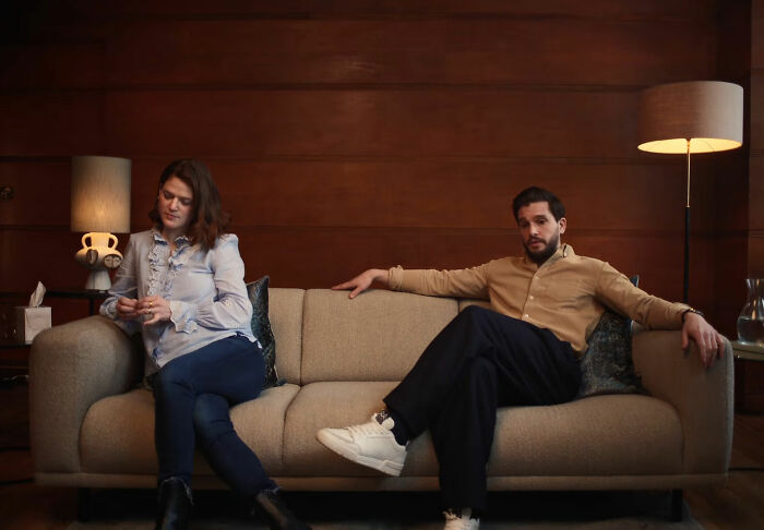 Couple seated apart on sofa in tense moment related to Game of Thrones star