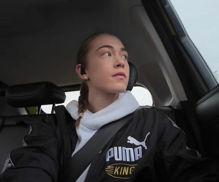HYROX athlete in a car, looking out the window, wearing a black Puma jacket and white hoodie.