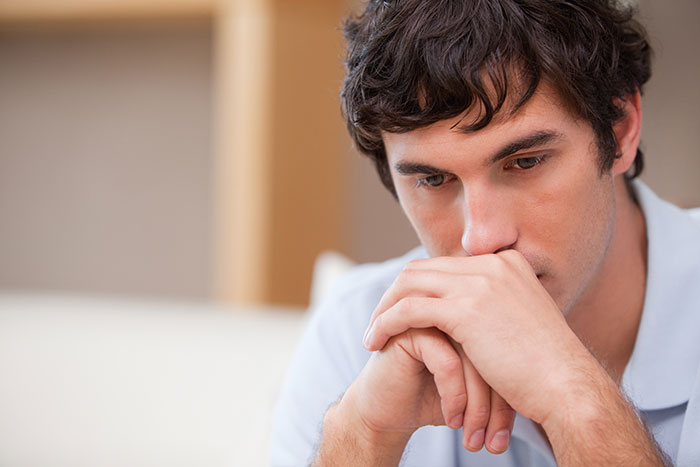 A man looking down with hands clasped, portraying a wild delayed plot twist from life.