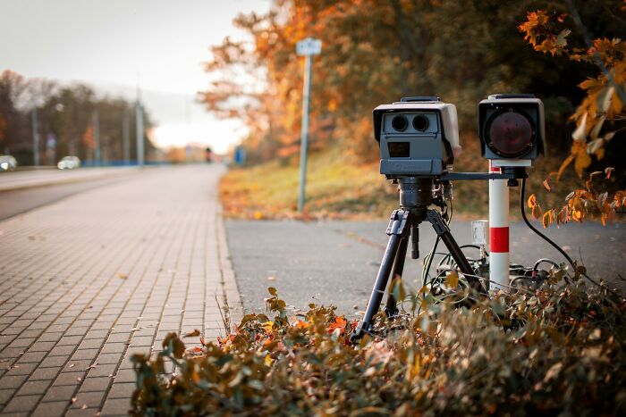 A speed camera on a tripod beside a pavement, relevant to ridiculous arguments in court.