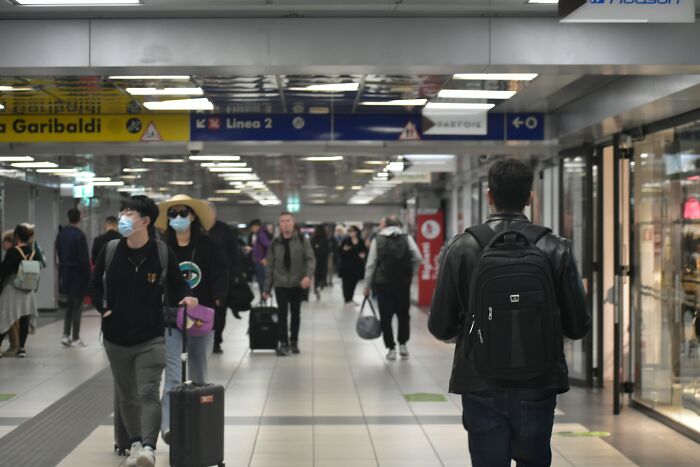 Busy airport corridor with travelers and luggage during vacation