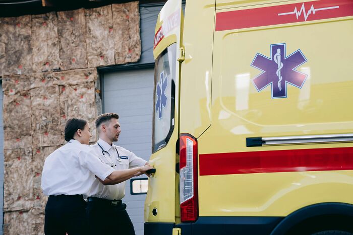 Two paramedics opening an ambulance door, depicting industry insiders in emergency services.