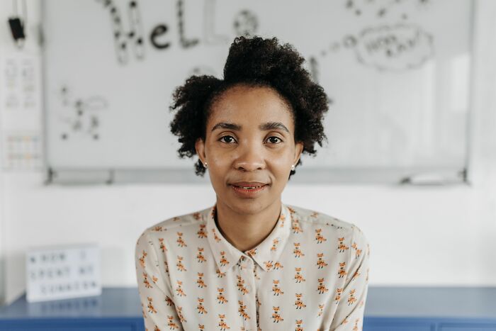 Woman with curly hair smiling in front of a whiteboard, symbolizing industry insiders getting used to dirty truths.