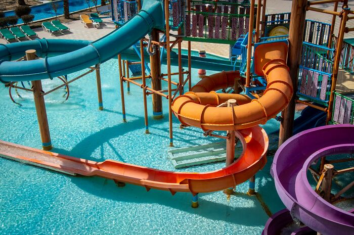 Vibrant water park with colorful slides and clear blue water, representing dirty truths in industry.