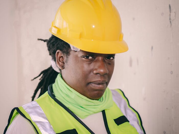 A construction worker in a hard hat and safety vest, showing industry truths and labor.