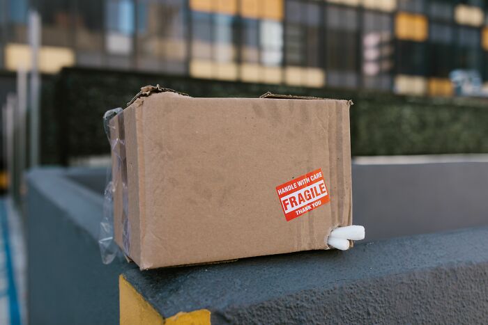 A damaged cardboard box with a 'FRAGILE' sticker, representing the dirty truths of packaging.