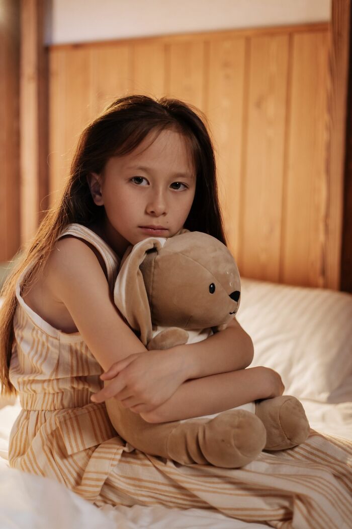 Sad girl hugging teddy bear alone family cut off reasons