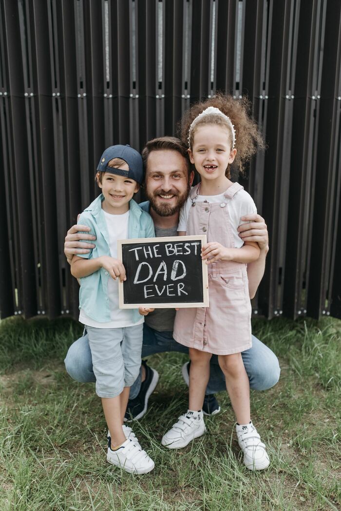Father with children holding sign saying best dad ever family cut off reasons