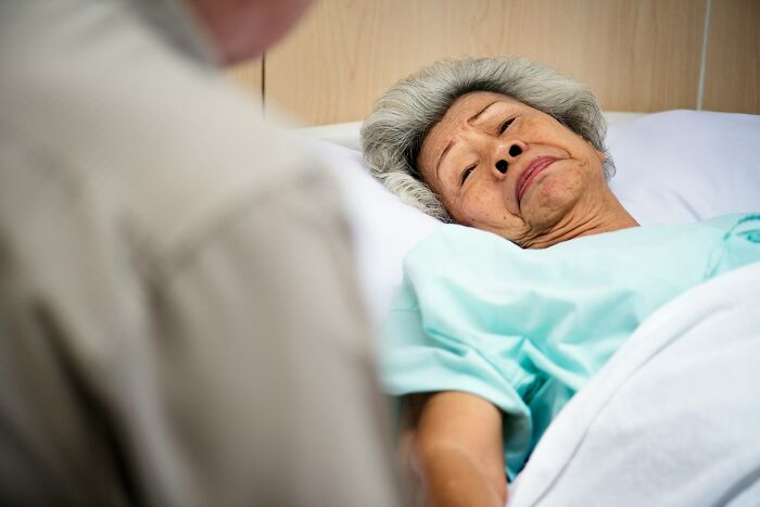 Elderly woman in hospital bed emotional family support