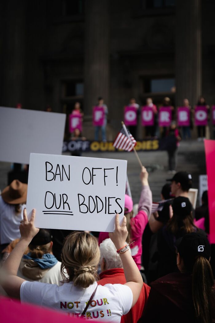 Protester holding sign at rally ban off our bodies family activism