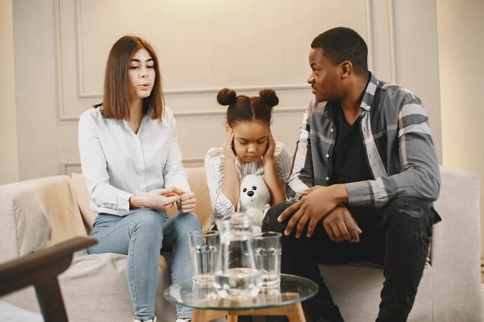 Family having serious conversation child covering ears family conflicts