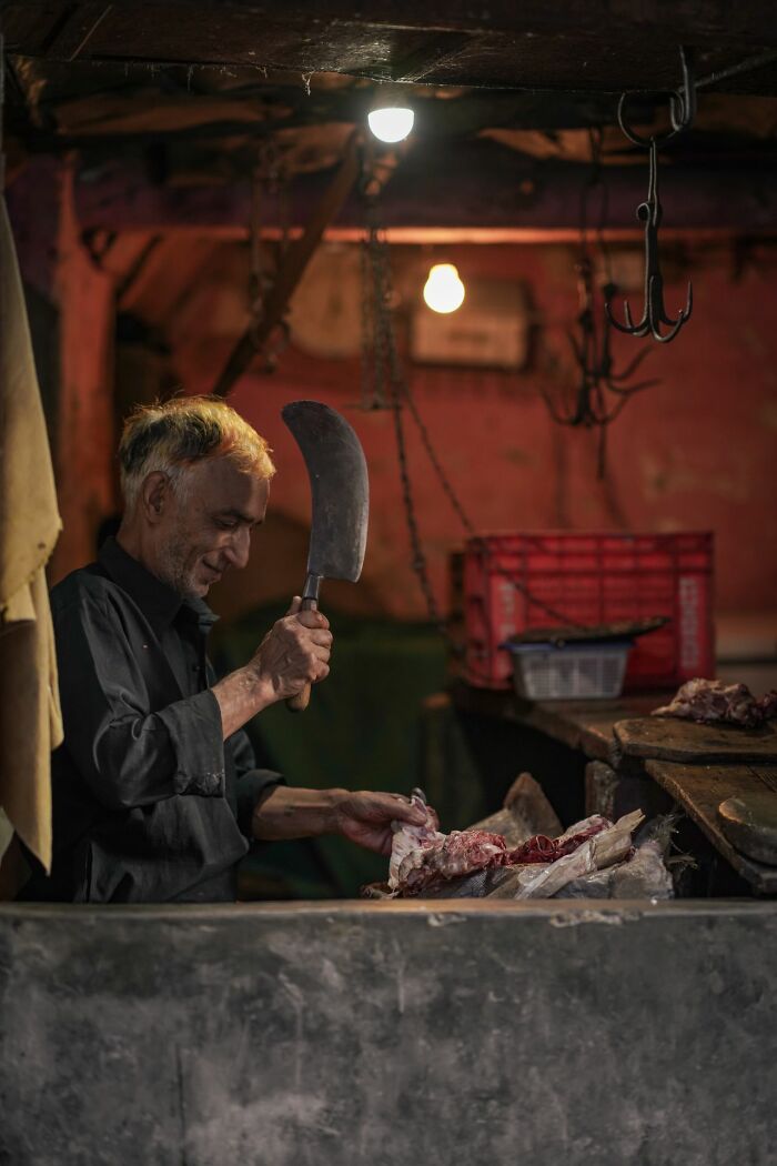 Butcher preparing meat under dim lights illustrating family cut off hardships