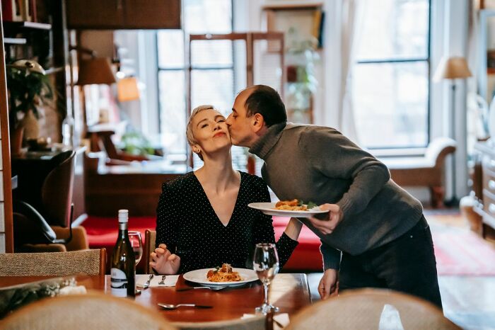 Couple sharing affectionate moment during dinner at home family relationships