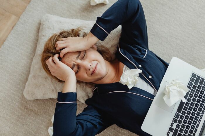 Stressed woman lying with laptop crying family cut off reasons