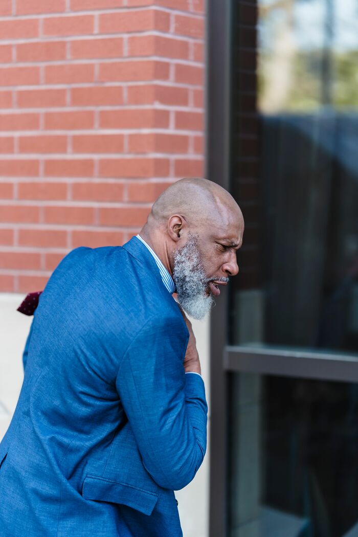 A man clutching his chest, illustrating a patient in medical distress who made a wrong health choice.